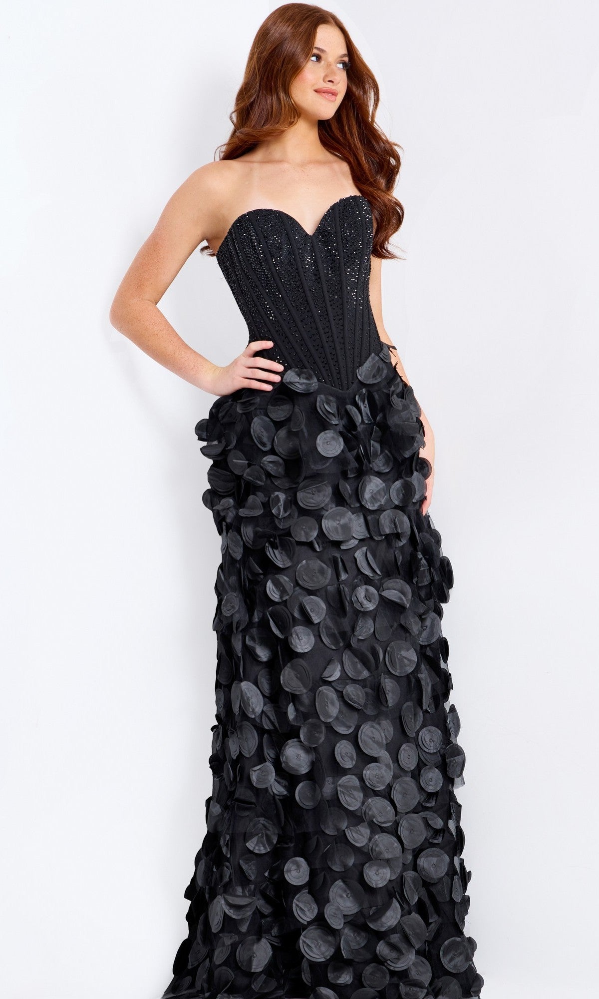 Woman wearing the Jovani 49384 Long Prom Dress, which features a strapless beaded corset bodice and a skirt adorned with large 3D petal appliqués.